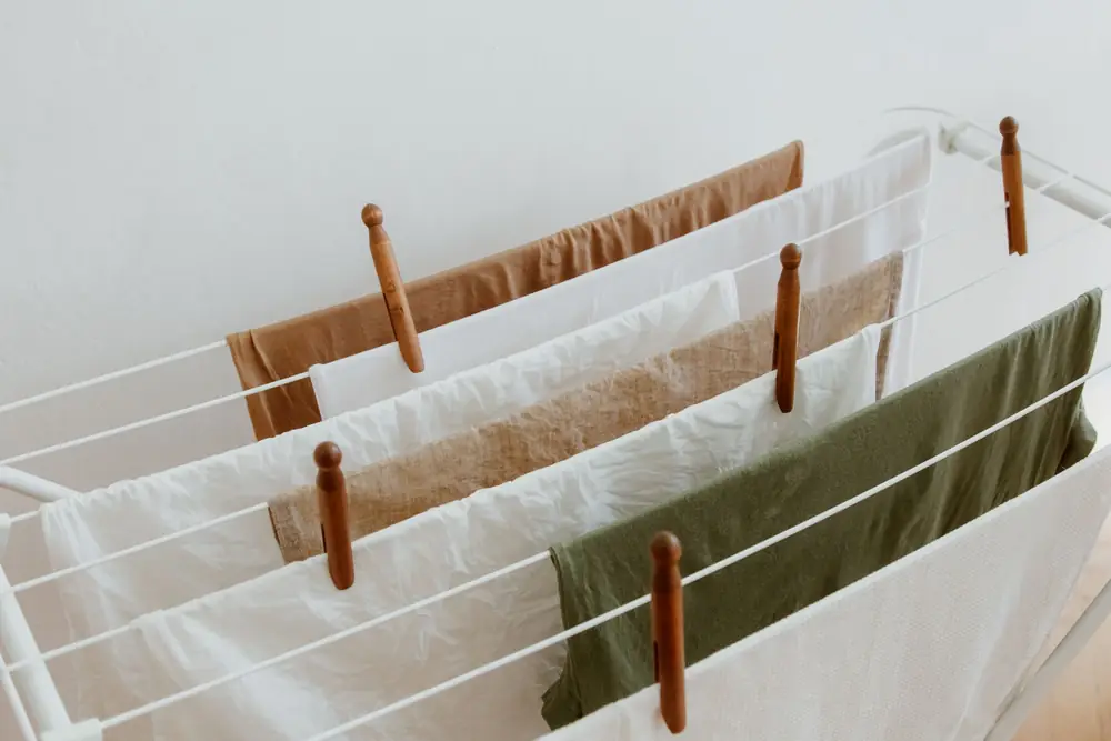 Laundry pegged in single layers across the rails of an indoor airer
